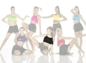 Seven dancers in colorful fringe costumes posing against white background