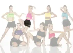 Seven dancers posing in colorful fringe costumes
