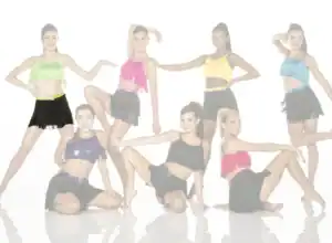 Seven dancers pose in colorful fringe costumes against white background.
