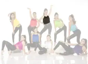 Nine young dancers pose in colorful fringe tops and black leggings.