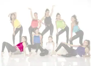 Young dancers posing in colorful fringe tops and black leggings