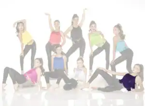 Nine young dancers posing in colorful fringe tops and black leggings