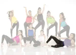 Young dancers pose in colorful fringe tops and black leggings.