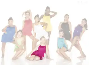 Young dancers in colorful fringe costumes posing in studio