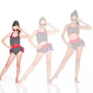Three girls pose in polka-dot dance costumes and sunglasses.