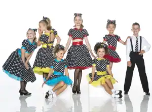 Children in polka-dot dance costumes posing in a studio