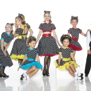 Children in polka-dot dance costumes posing in a studio