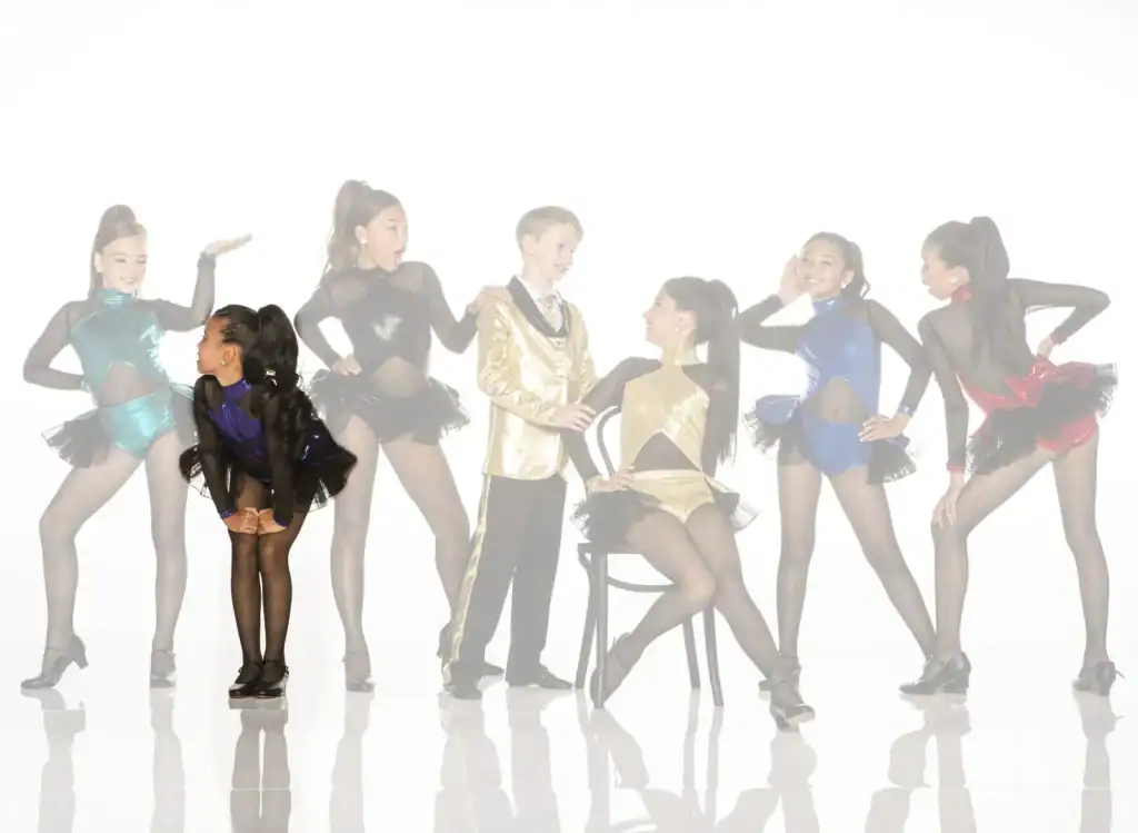 Young dancers posing in colorful costumes against white background