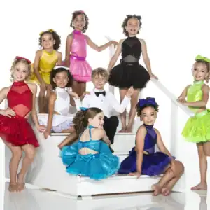 Children in colorful dance costumes posing on white stairs