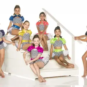 Seven young dancers in colorful checkered costumes posing on stairs