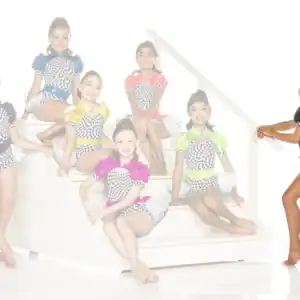Seven young dancers in colorful checkered costumes posing on stairs