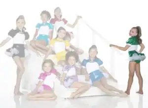 Young dancers in colorful costumes pose on white stairs