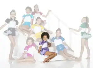 Young dancers in colorful costumes pose on white stairs