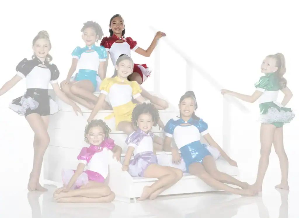 Young dancers in colorful costumes pose on white stairs