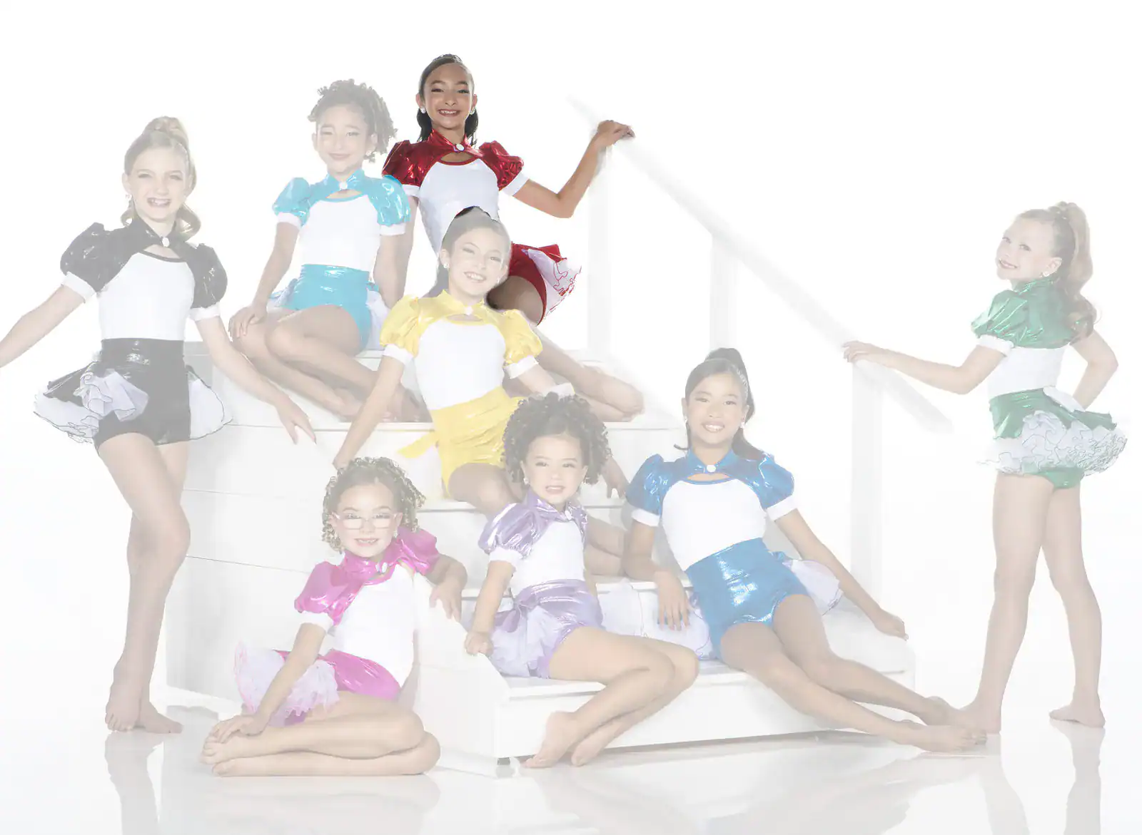 Young dancers in colorful costumes pose on white stairs