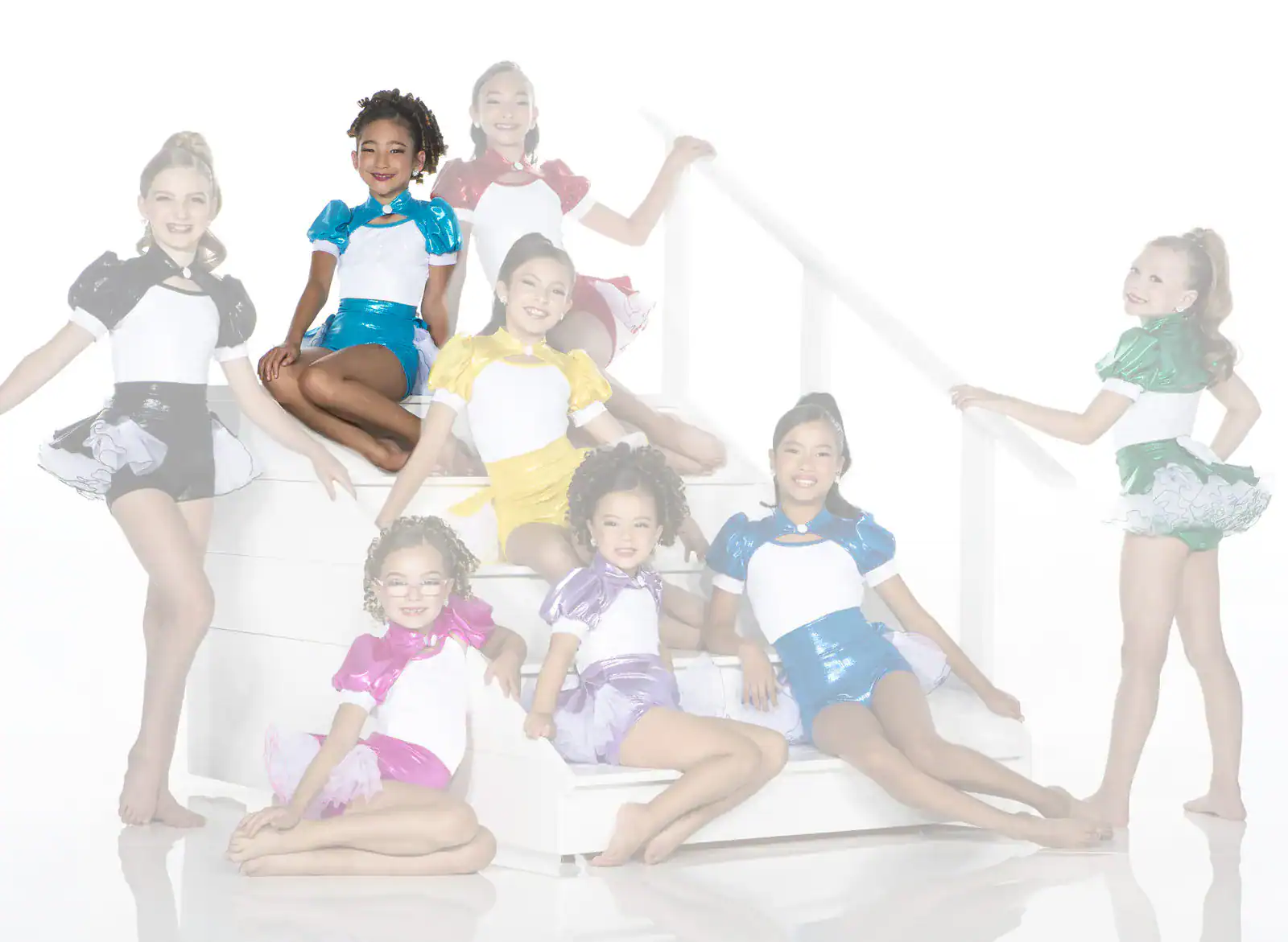 Young dancers in colorful costumes posing on white stairs