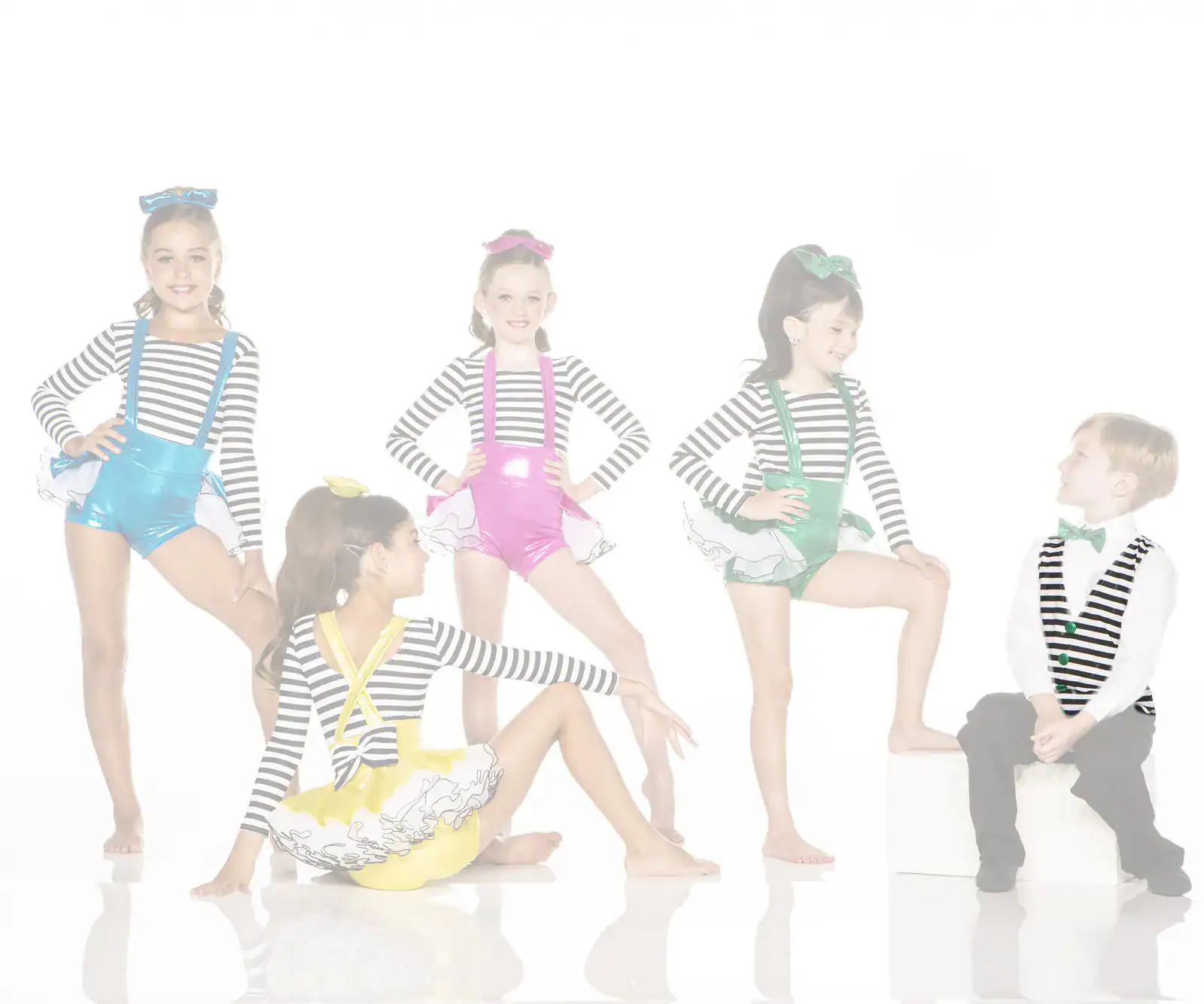 Children in colorful striped dance costumes posing in studio