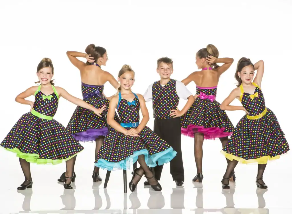 Children in colorful polka-dot dance costumes posing in a studio