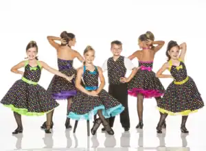 Children in colorful polka-dot dance costumes posing in a studio