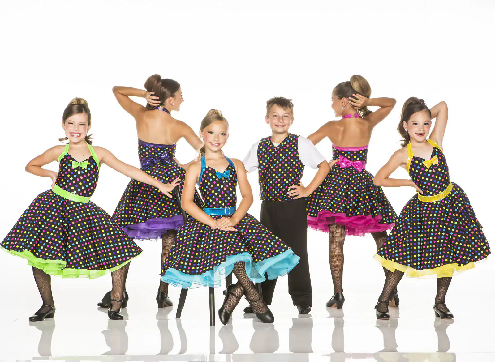 Children in colorful polka-dot dance costumes posing in a studio