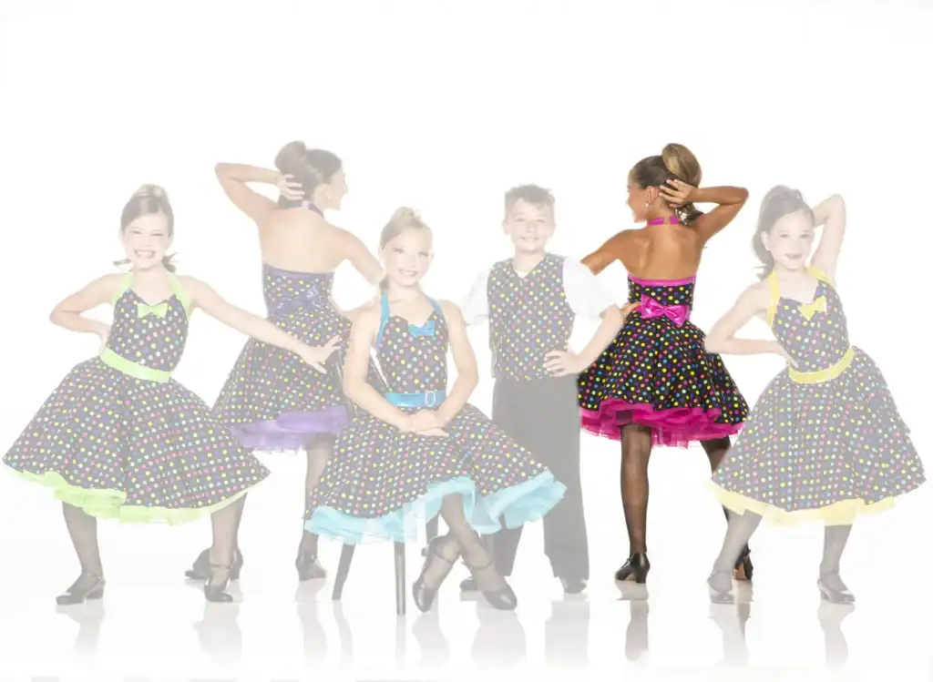 Children wearing colorful polka-dot dance costumes pose together