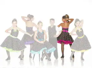 Children wearing colorful polka-dot dance costumes pose together