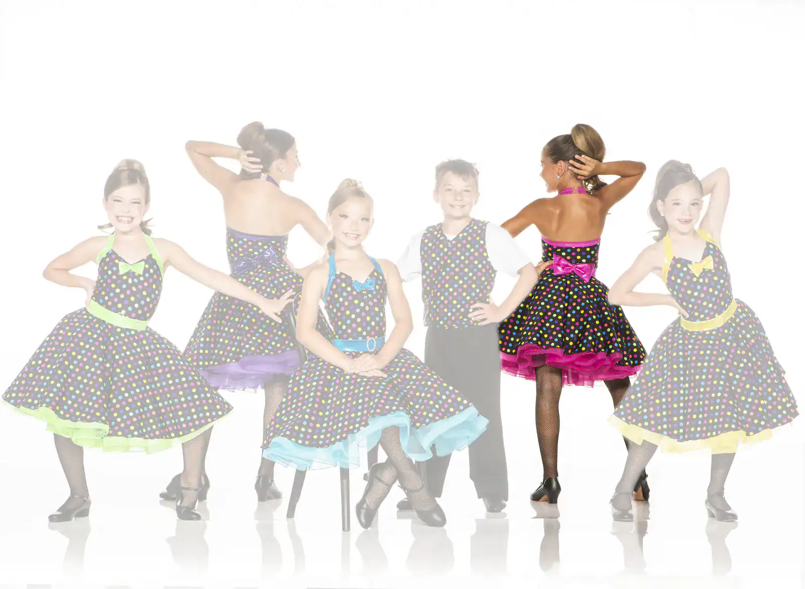 Children wearing colorful polka-dot dance costumes pose together