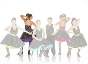 Children in colorful polka-dot dance costumes posing together