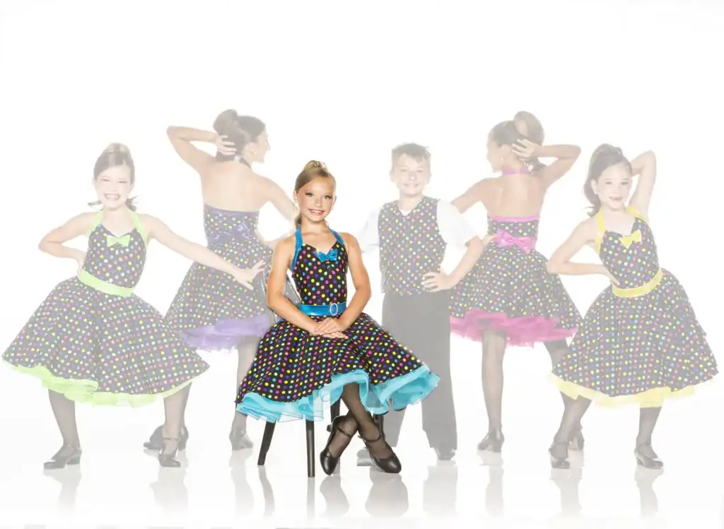 Young dancers in colorful polka-dot costumes posing together