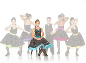 Young dancers in colorful polka-dot costumes posing together