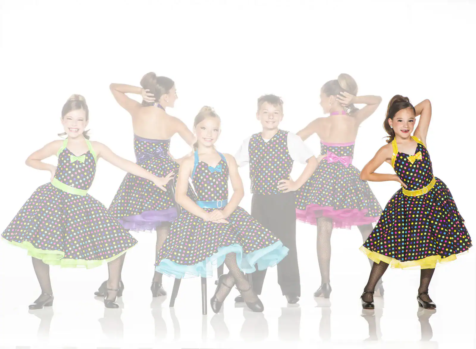Young girl modeling a black polka-dot dance dress with yellow trim.