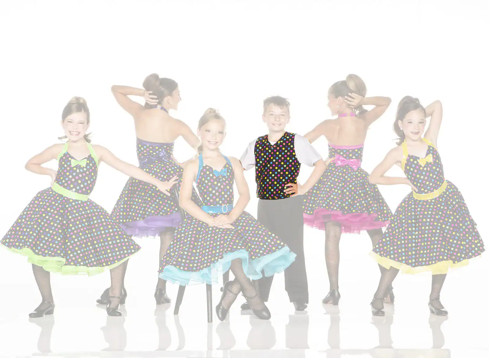Five children pose in colorful polka-dot dance costumes.