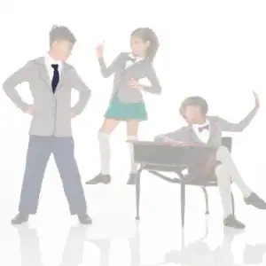 Three children in school uniforms posing around a classroom desk