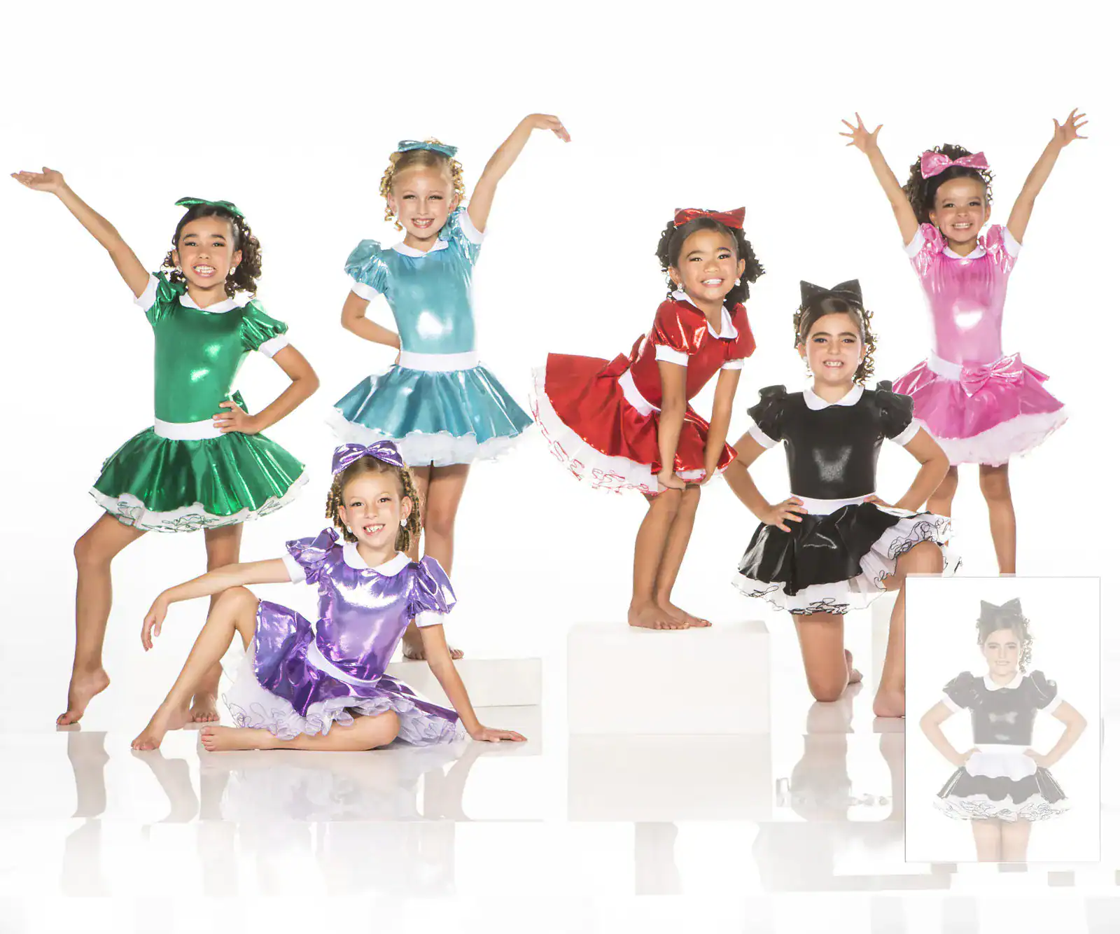 Six girls pose in colorful shiny dance costumes.