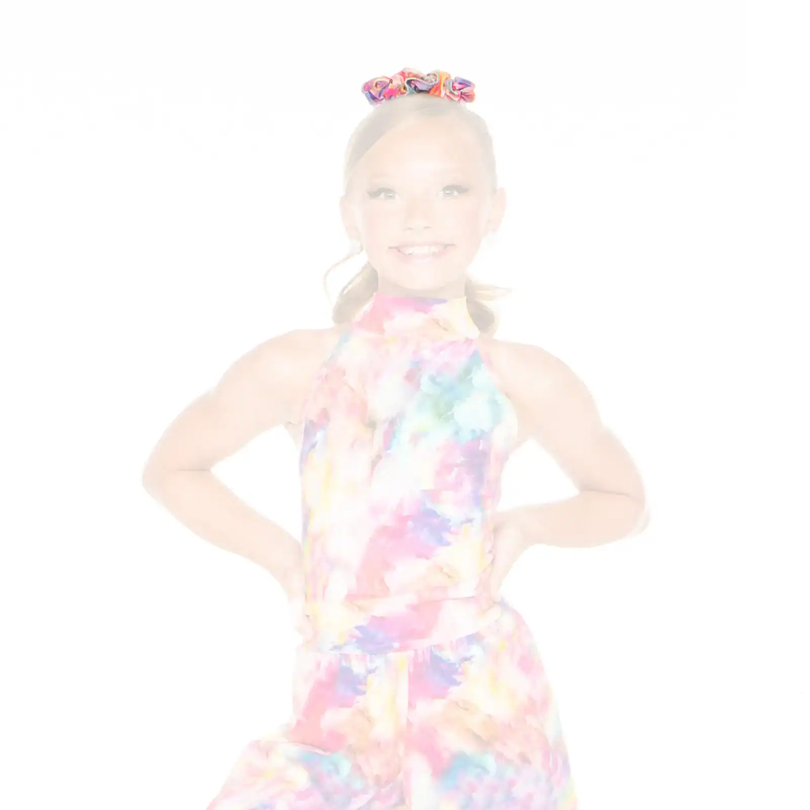 Smiling girl wearing a colorful tie-dye outfit and scrunchie