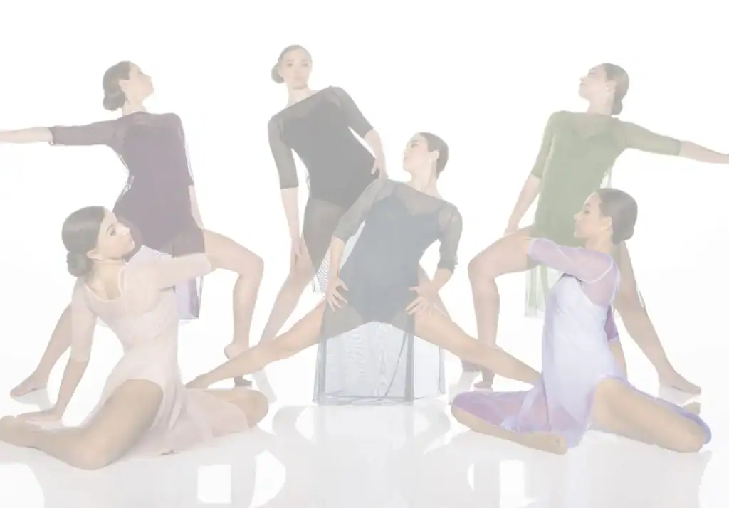 Six contemporary dancers pose in flowing dresses against white backdrop.