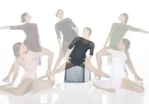 Six dancers pose in sheer dresses against white background.