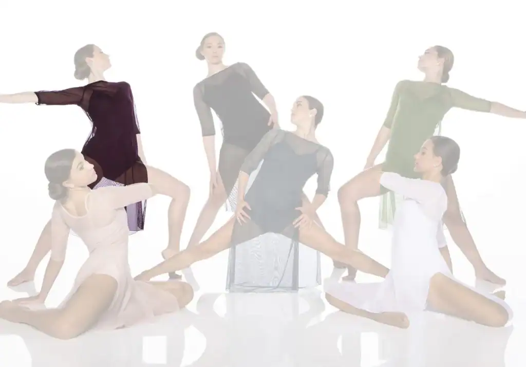 Six dancers pose in flowing dresses against white background.