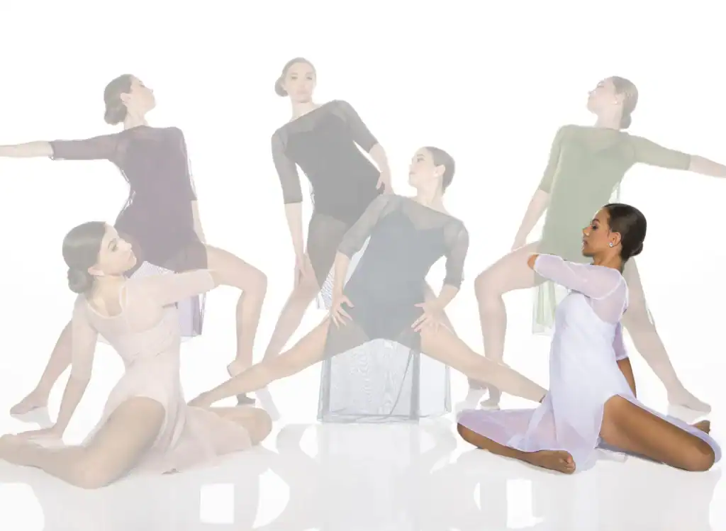Dancers in sheer costumes posing against a white backdrop