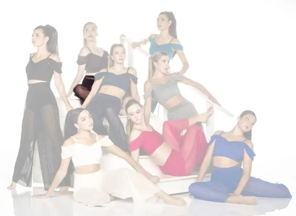 Eight women in colorful dance outfits posing on white stairs