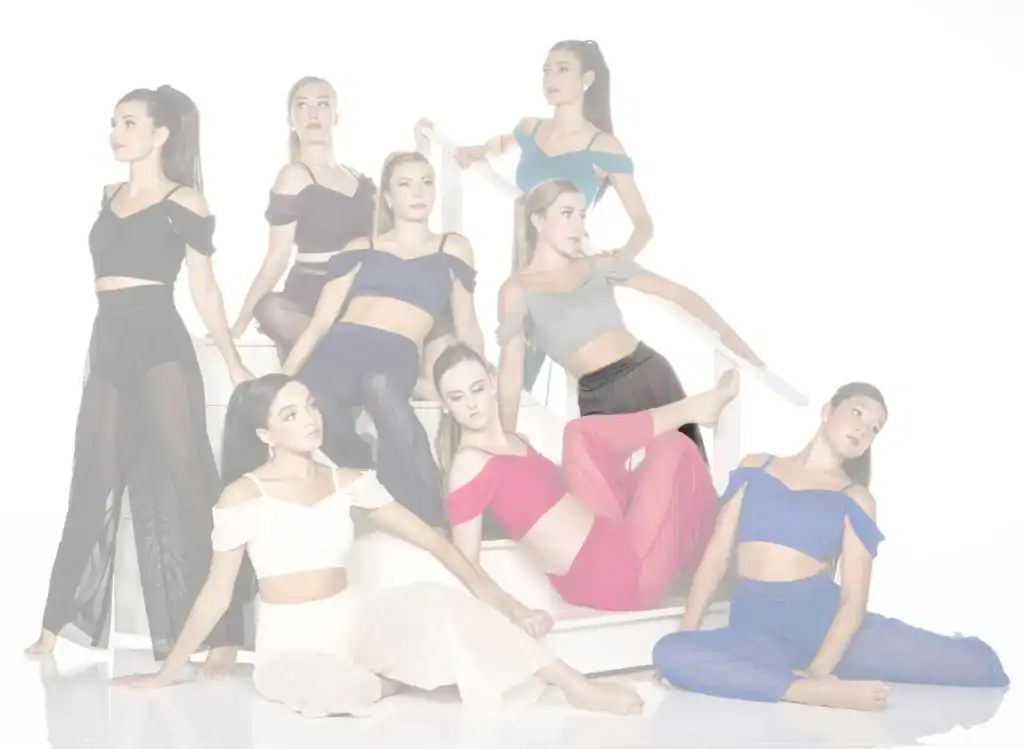 Nine women pose in colorful outfits on white stairs.