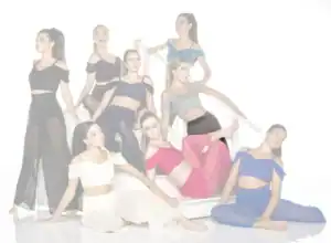Nine women pose in colorful outfits on white stairs.