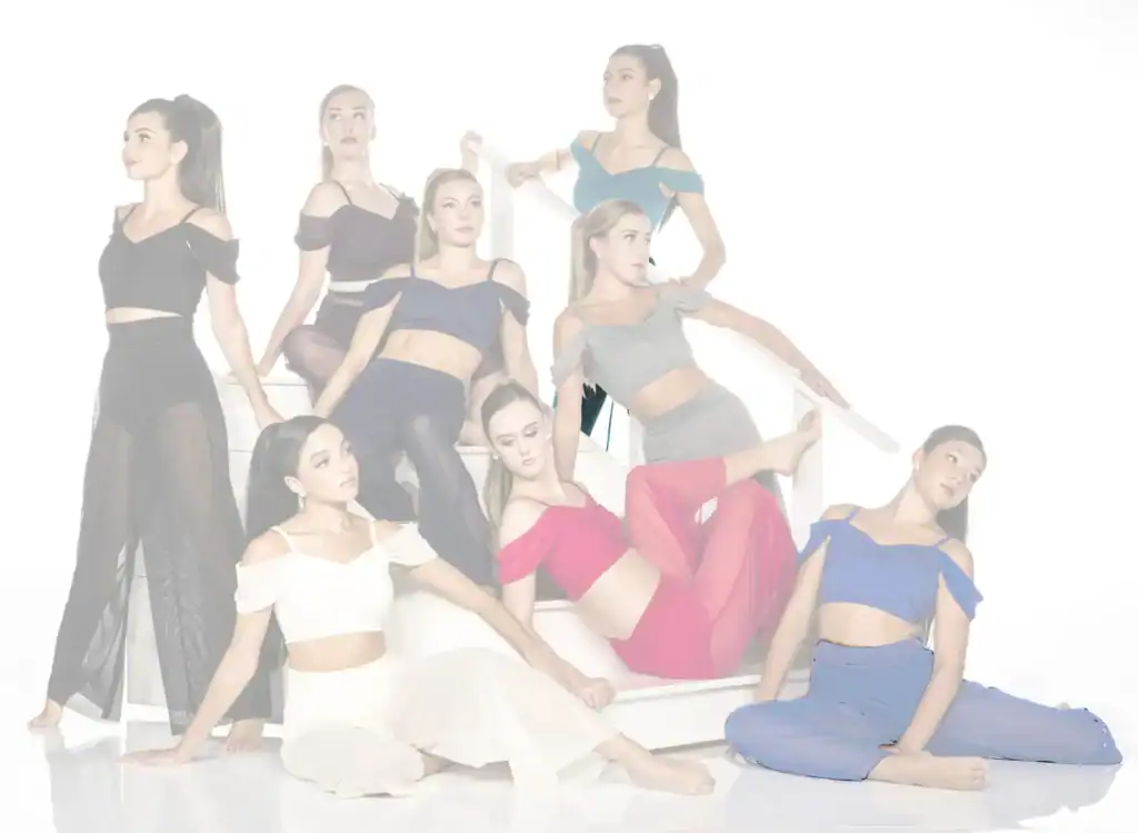 Eight dancers pose in colorful costumes on white stairs.