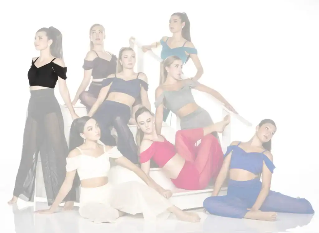 Eight dancers in colorful outfits pose on a white staircase.