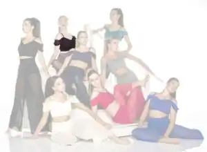 Nine women pose stylishly on a white staircase.