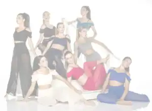 Eight women posing in colorful outfits on white stairs