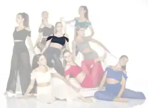 Eight women pose on stairs in colorful coordinated outfits.