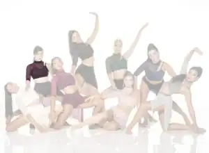 Eight dancers posing in coordinated contemporary dance costumes
