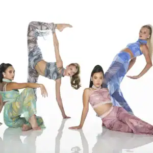 Four dancers posing in colorful marbled outfits on white background