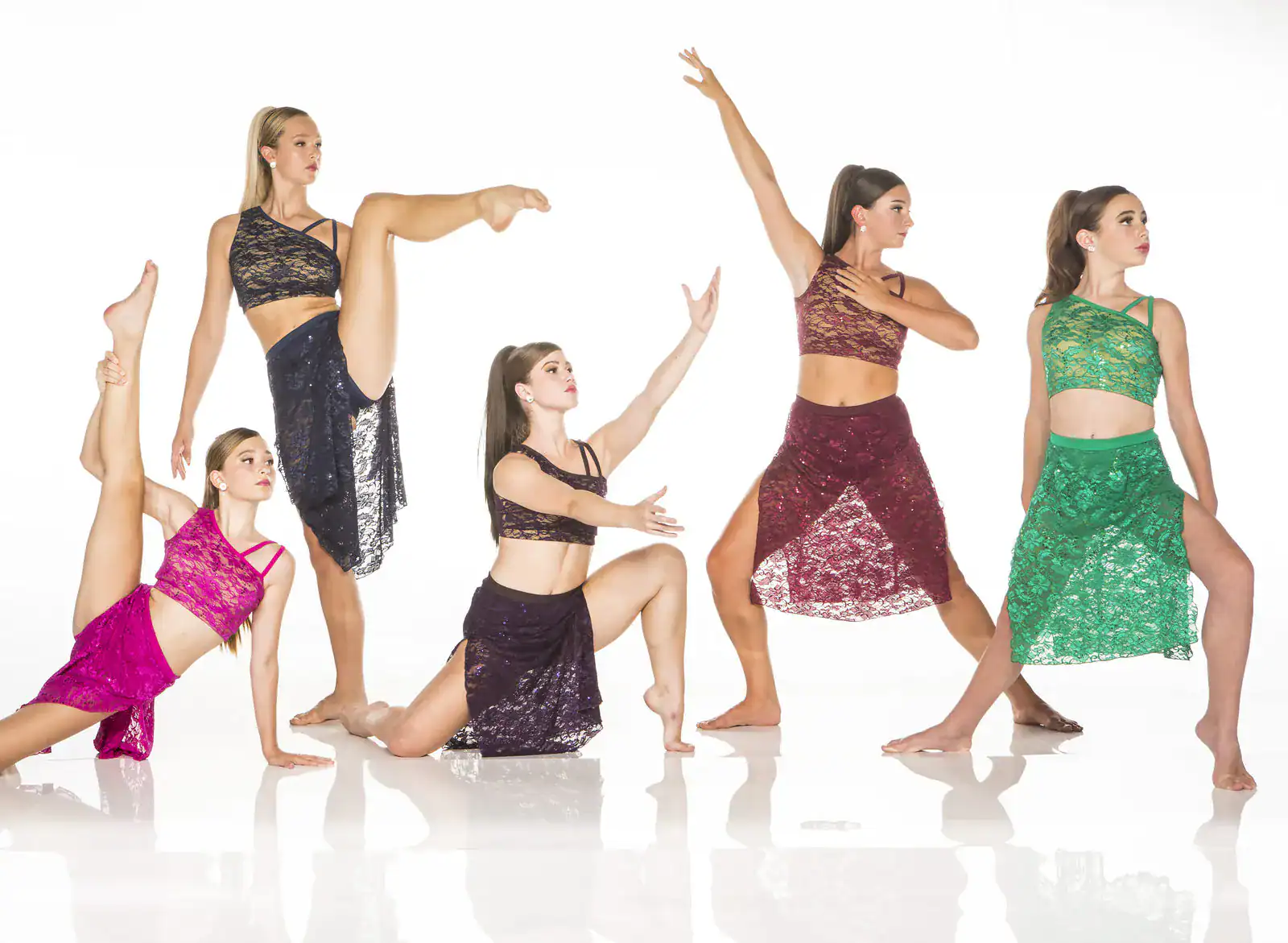 Five dancers posing in colorful lace costumes
